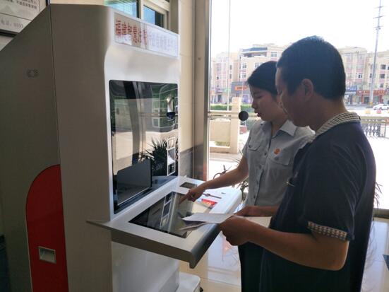 图为法官引导当事人使用自助服务终端进行自助立案、查询等功能
