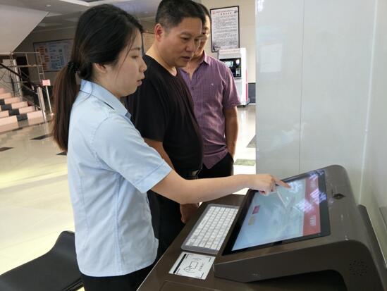 图为法官引导当事人使用文书自动填单机