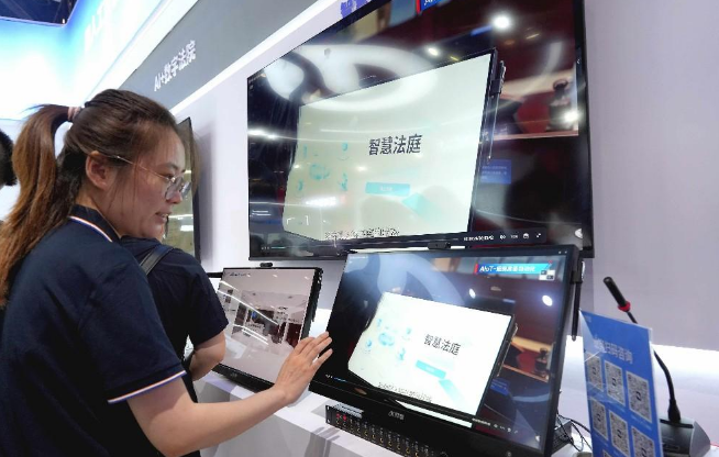 图为观众观看科大讯飞展示的智慧法庭项目。