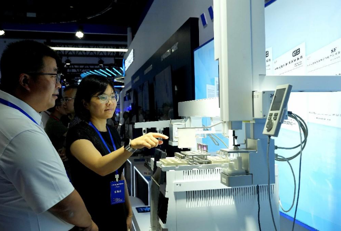 图为观众观看全自动血液中乙醇成分鉴定仪。